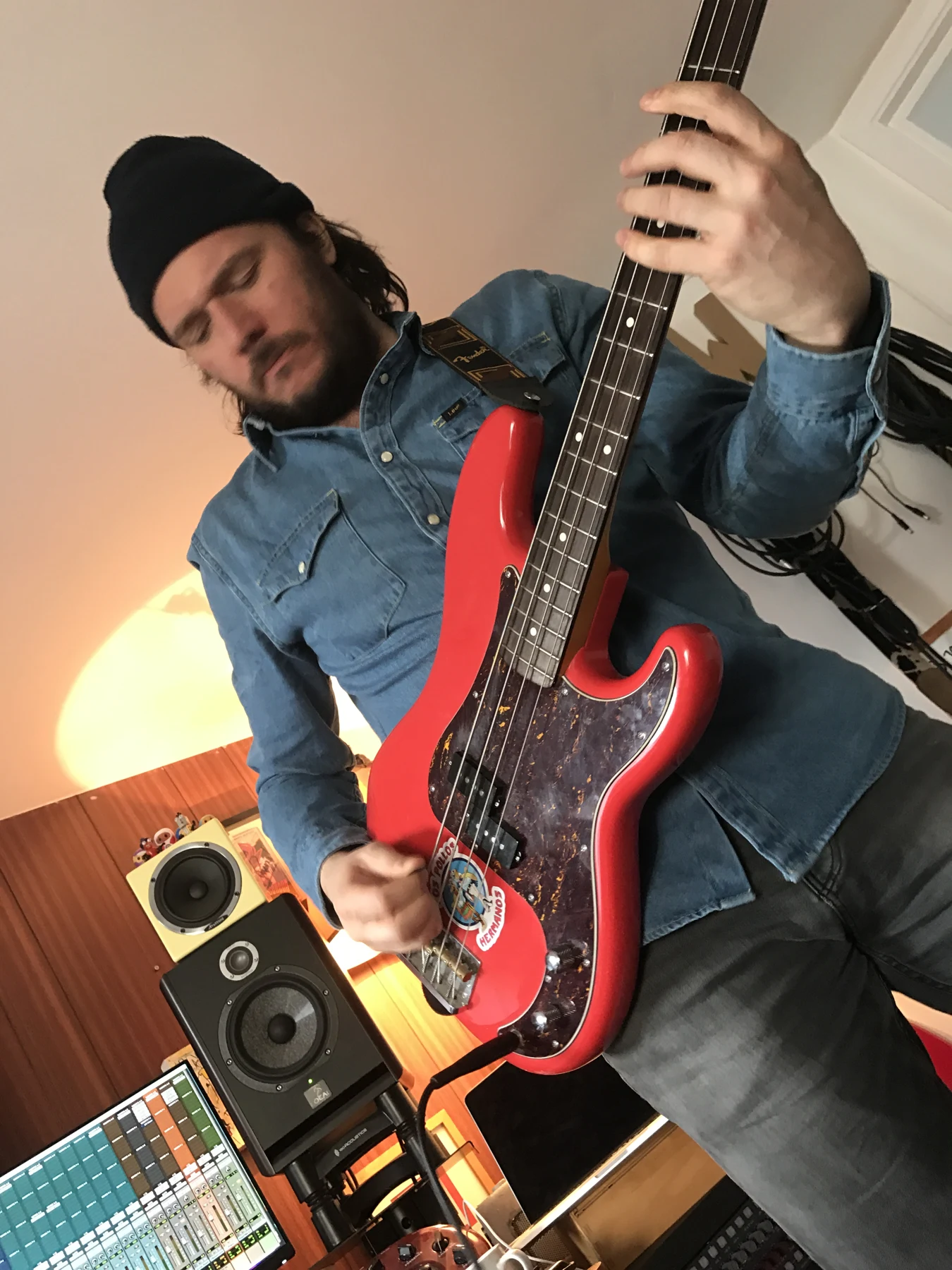 Wag playing a red bass guitar in the studio
